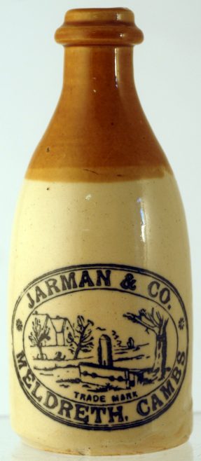 JARMAN & CO GINGER BEER BOTTLE. 7ins tall, ch. t.t. 'JARMAN & CO/ MELDRETH CAMBS' village stocks scene pictured. Tiny insignificant inside rim flake, & 1 to base. Extremely rare. NR £120-150+. | Advertised for sale on BBRA Collectors Mart Auction website,Saturday 2nd and Sunday 3rd October 2010