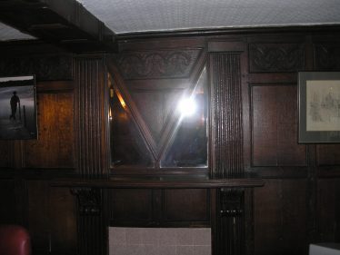 The AM mirror in the Oak Room in Meldreth Court. Note the letter M and the inverted A in the mirror design.  The date of the mirror is not known. | Photograph by Tim Gane