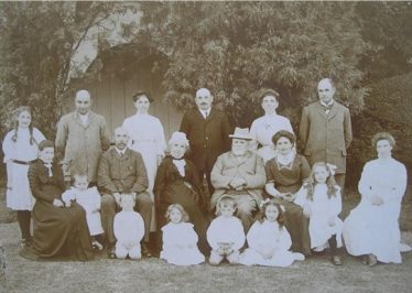 The Palmer family shown outside the summer house in Old Elmcroft, Meldreth c.1909. William Palmer is thought to be the tall figure standing in the back row on the right. | Photo courtesy of Robert Elbourn