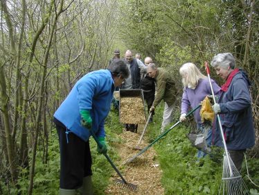 Volunteers laying wood chippings on one of Meldreth's footpaths